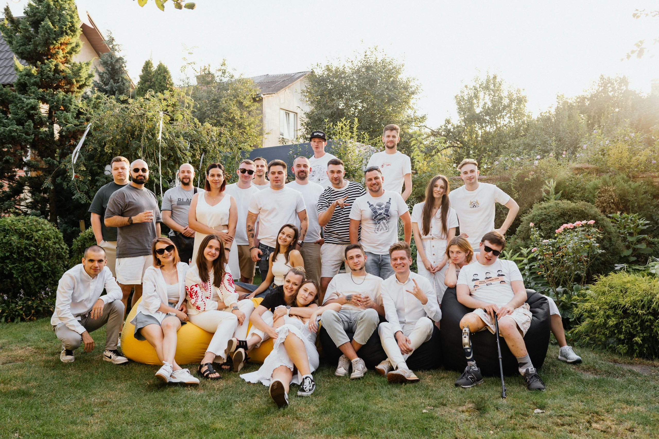 Large group of friends having fun outside in a garden on a sunny day in Kyiv, Ukraine.